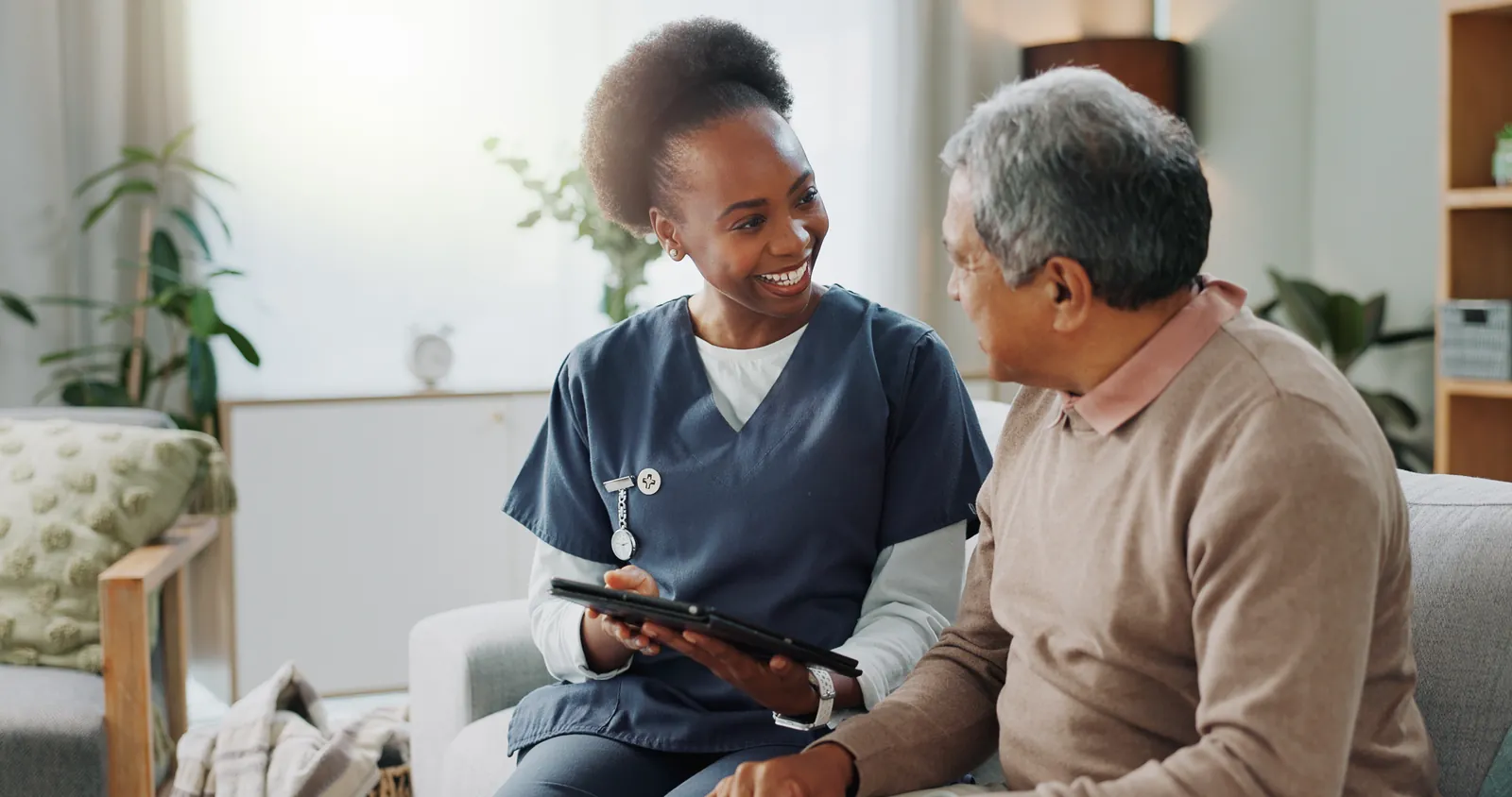 Nurse chatting with an older man during an afternoon visit